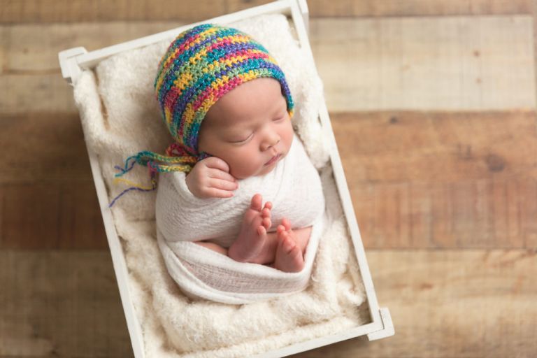 sleeping newborn with rainbow bonnet