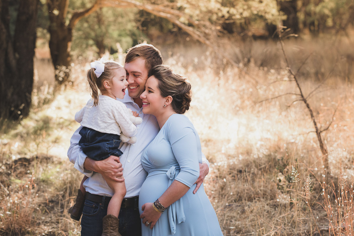 Parents holding and laughing with their little girl