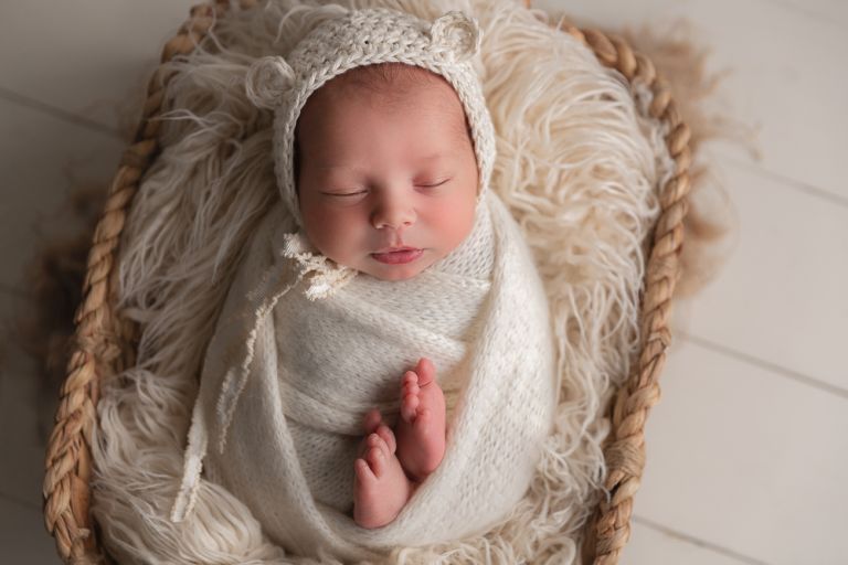 newborn baby with a teddy bear bonnet