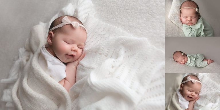 newborn smiling baby girl sleeping on white blanket