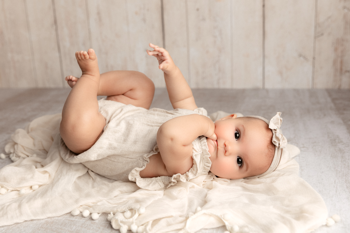 3 month old baby girl on her back with her toes in the air